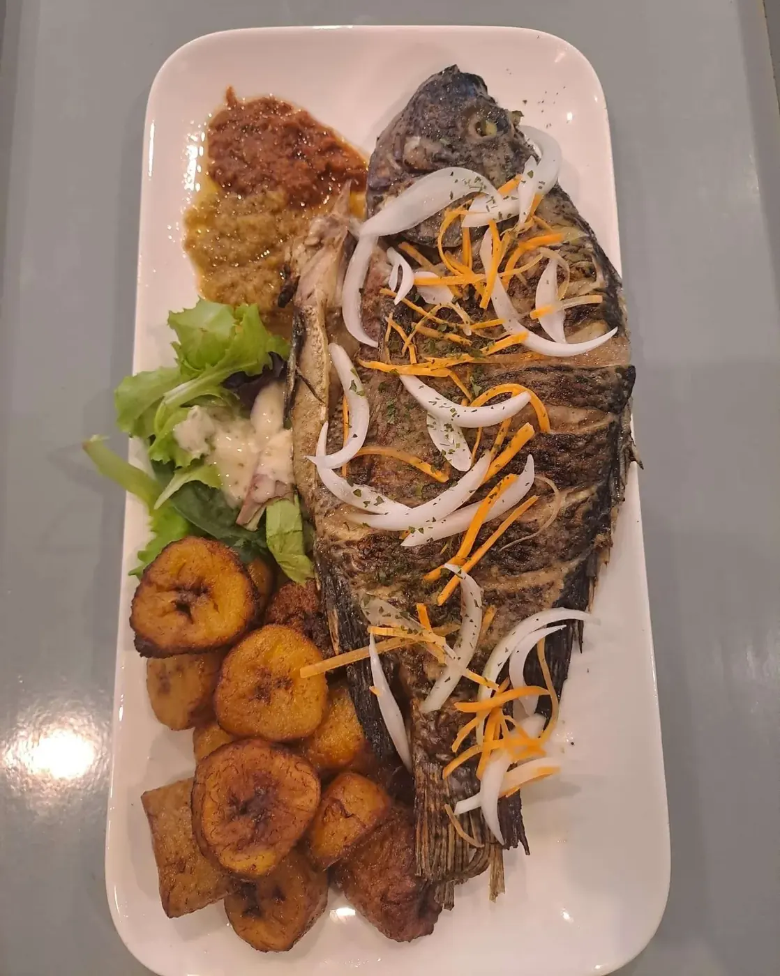 Tilapia braisé entier et plantains frits